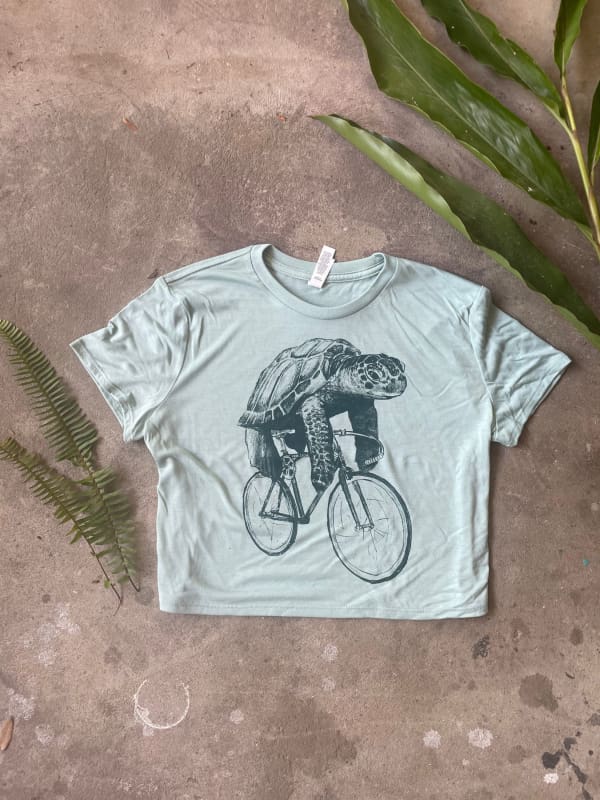 Sea turtle on a Bicycle Women’s Crop Tee - Dusty Blue / S - Ladies Tees